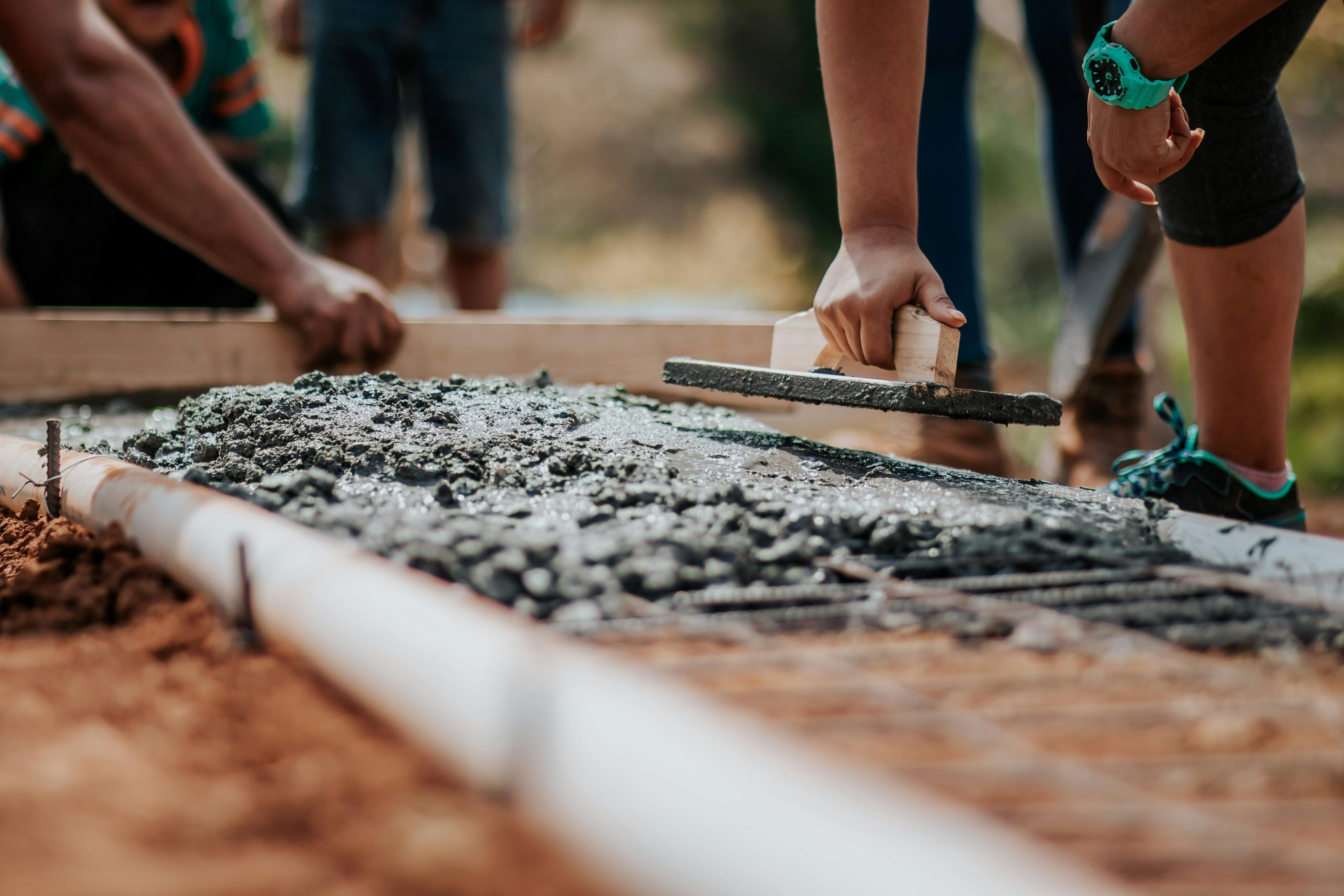 O scenă de construcție în plină desfășurare, cu mai mulți muncitori care colaborează pentru a finaliza proiectul.